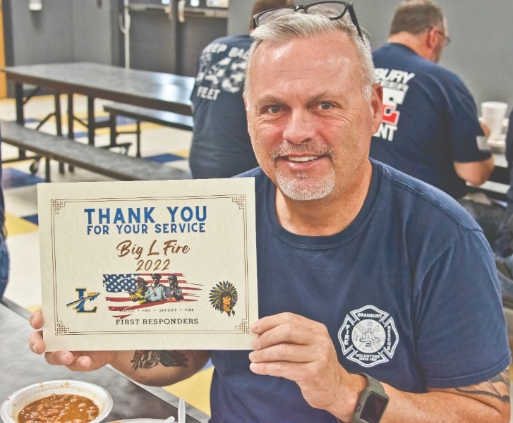 FIRST RESPONDERS HONORED: Granbury Fire Department’s Tim Hallman proudly shows the certificate handed out to all the volunteer teams at the Lipan community appreciation barbecue dinner.